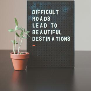 Sign saying "Difficult roads lead to beautiful destinations"