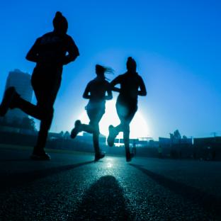 Three people running at dusk