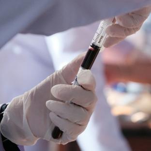 Photo of lab technician with a test tube of blood