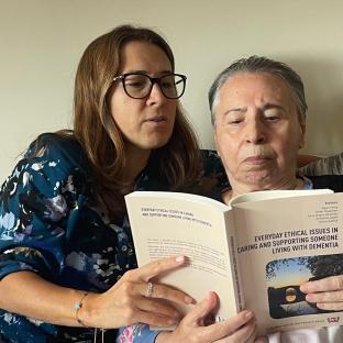 Sertac and her mother reading the book “Everyday Ethical Issues in Caring and Supporting Someone Living with Dementia”